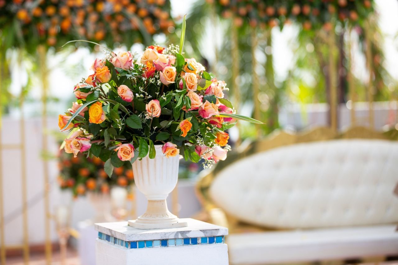 Vibrant floral arrangement with roses in elegant vase, perfect for weddings or events.