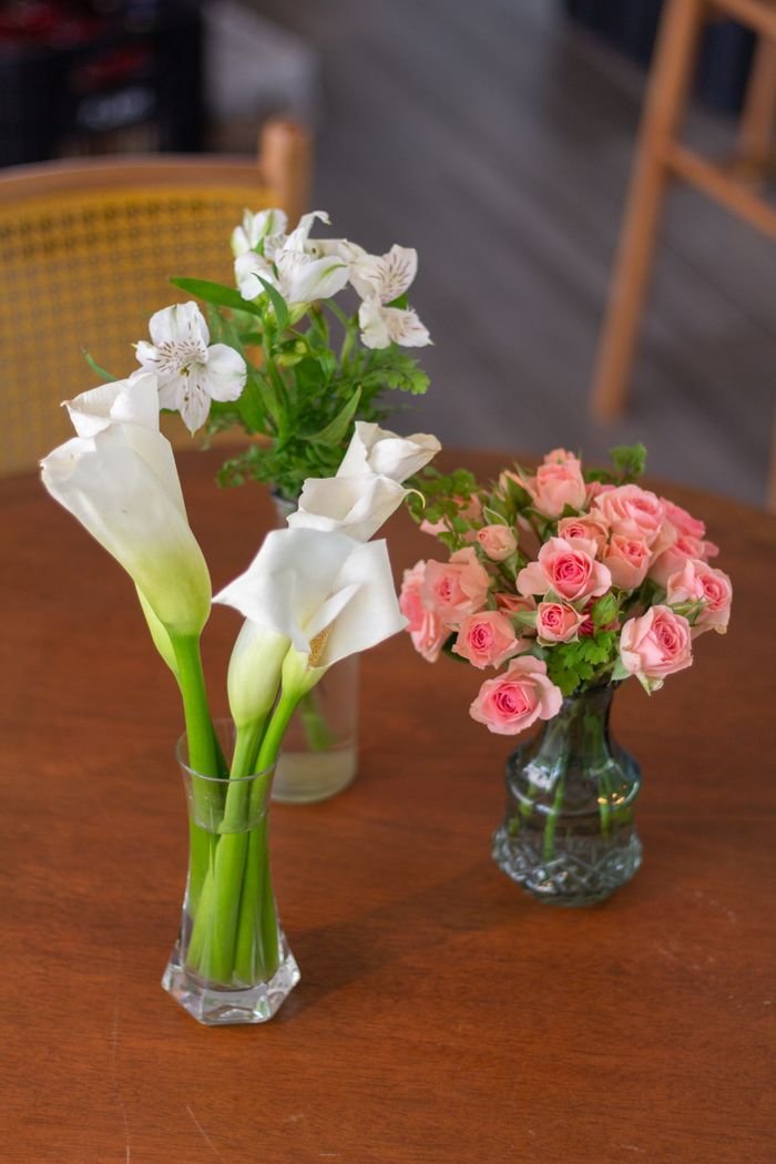 Beautiful floral arrangements of roses and lilies on a wooden table in São Paulo.