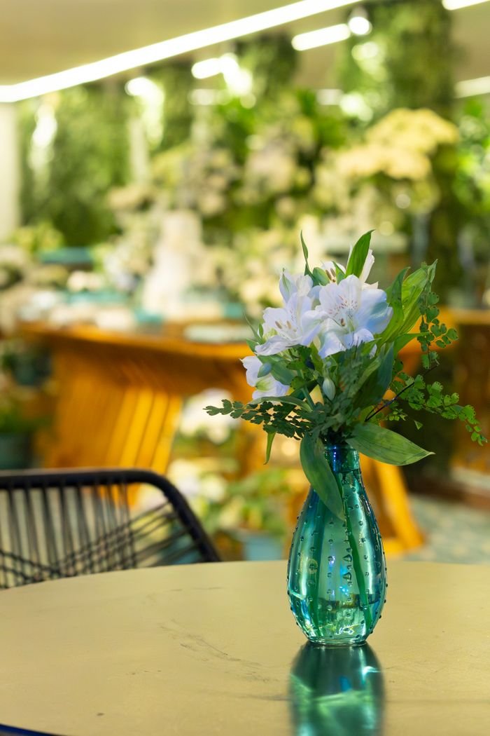 Beautiful floral arrangement in a blue vase at an indoor wedding in São Paulo.