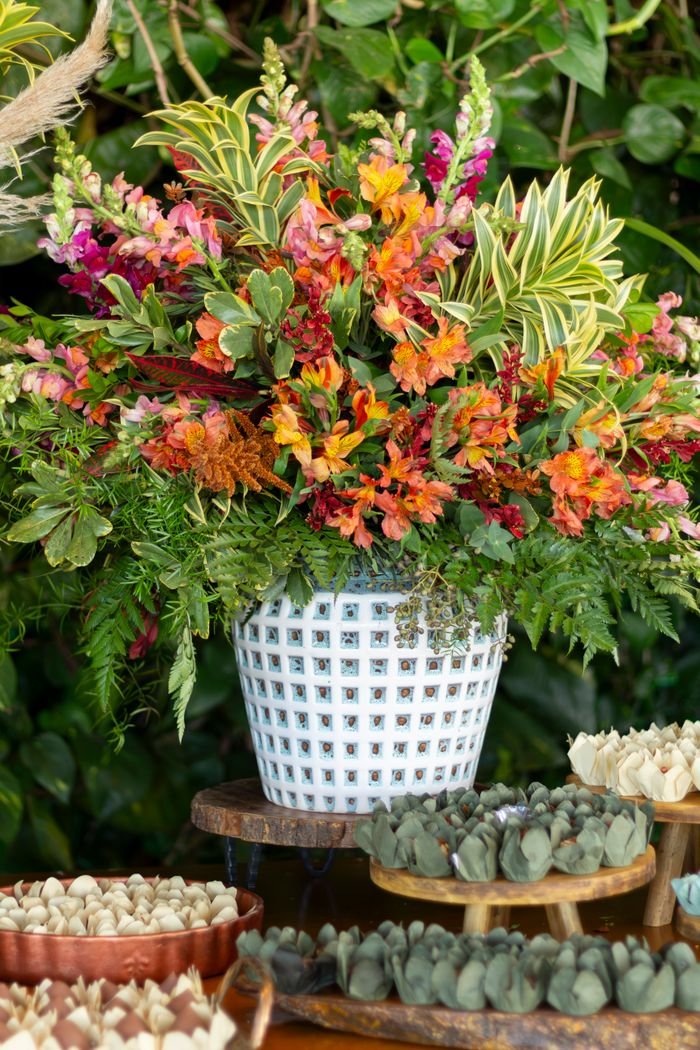 Stunning orange and green floral display with sweets at a São Paulo wedding event.